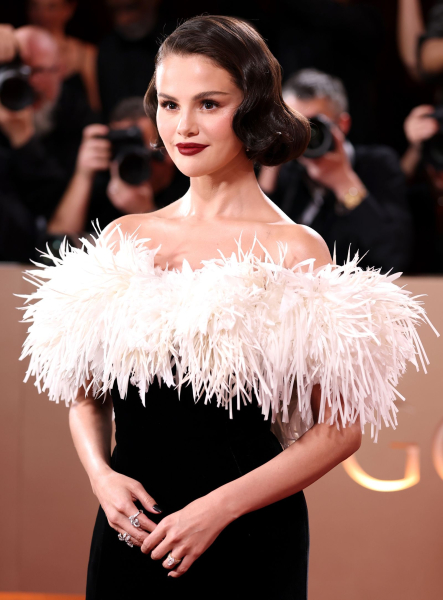 Selena Gomez poses in a black and white off the should dress at the golden globes